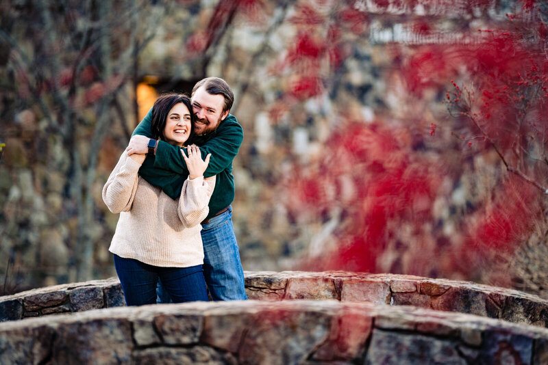 Couple laughs together on a bridge at Yates Mill Park in Raleigh, NC