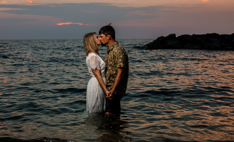 Couple standing in Lake Erie and kissing at sunset on Presque Isle State Park