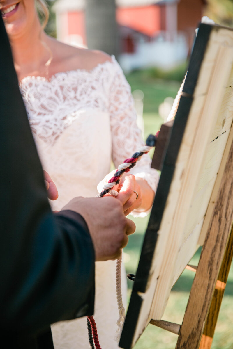 Bride and groom tying a cord of three strands  as unity ceremony
