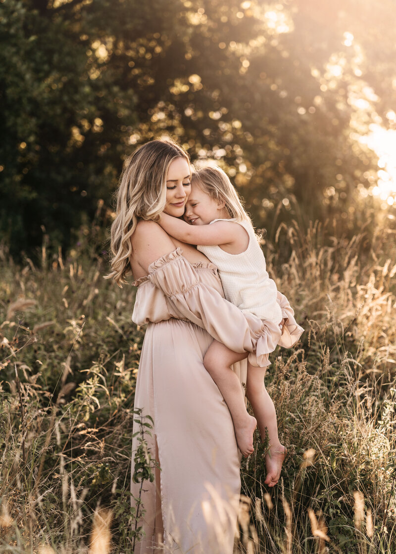 Photo of a mother holding her child during a family photoshoot in Shrewsbury at sunset