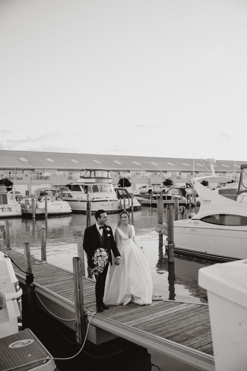 bride and groom walking on a dock