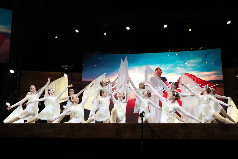 Dancers in white dresses with flags at performance in Texas