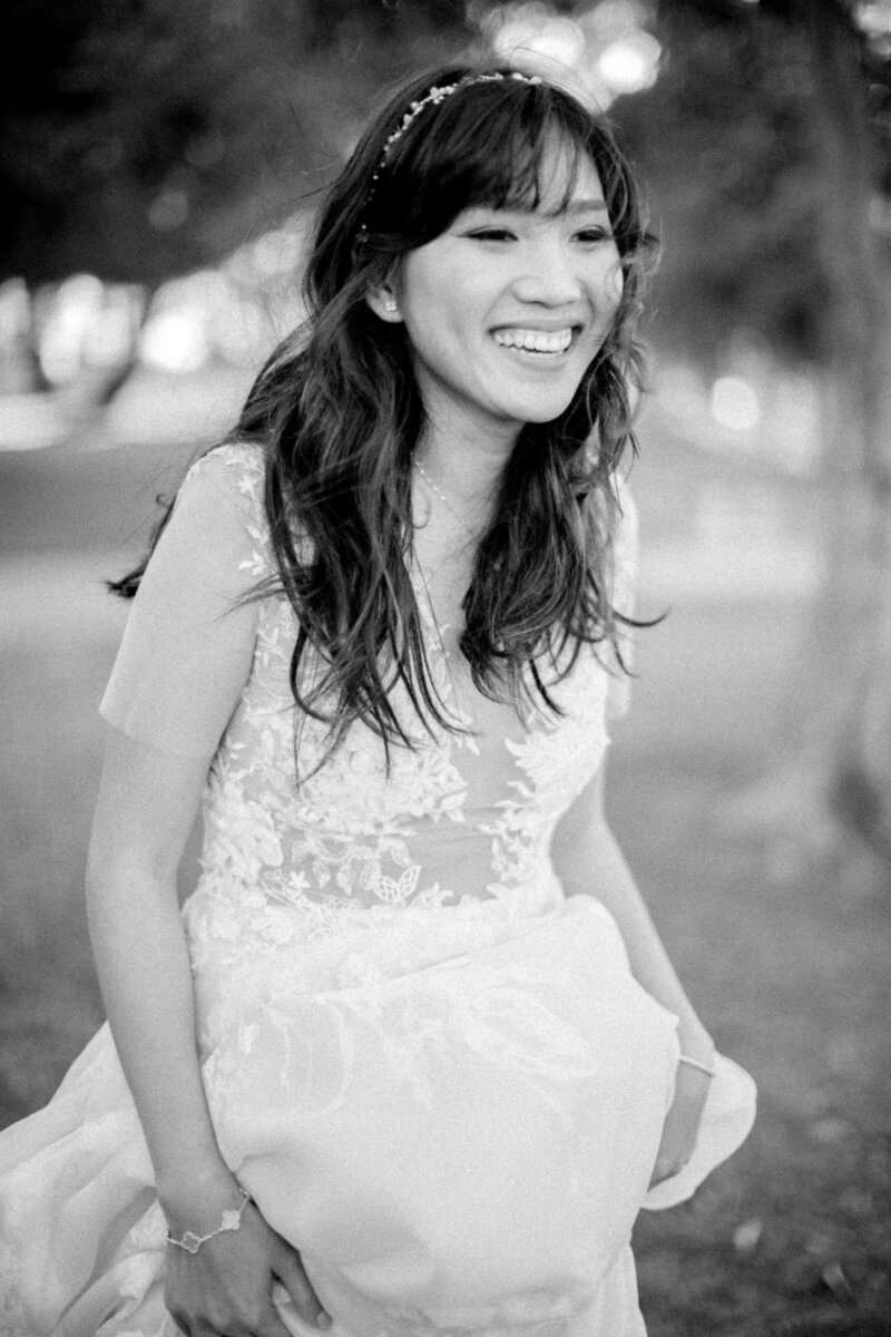 bride in black and white smiling with white lace dresss