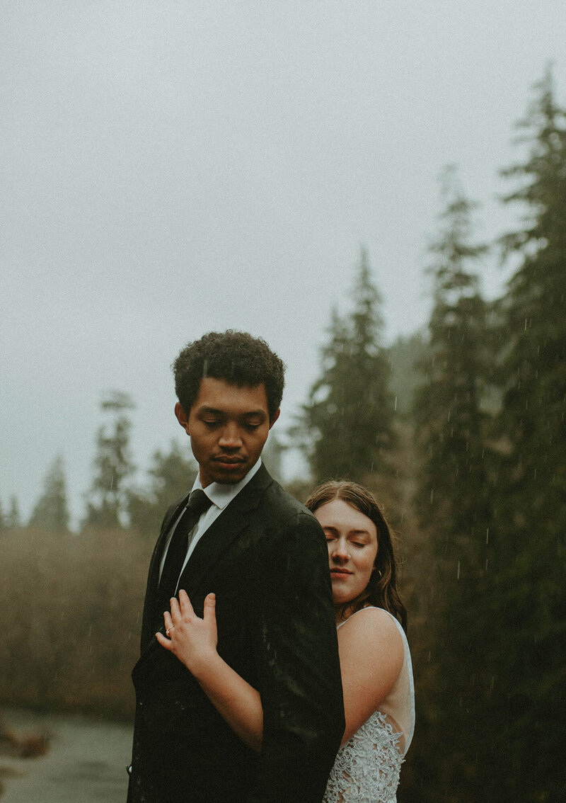 couple hugging in forest during their wedding day