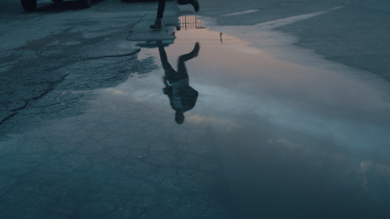 Young man running through a puddle-FillmCo
