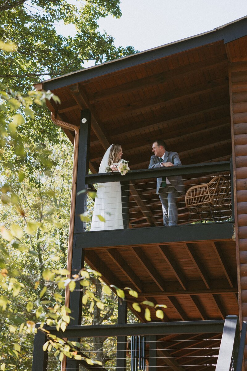 Couple standing on balcony of cabin during north georgia elopement.