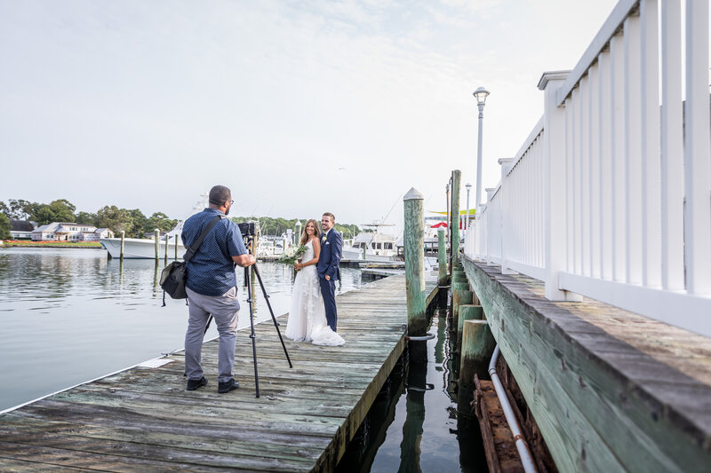 Wedding vidoegrapher videoing bride and groom on peer deck