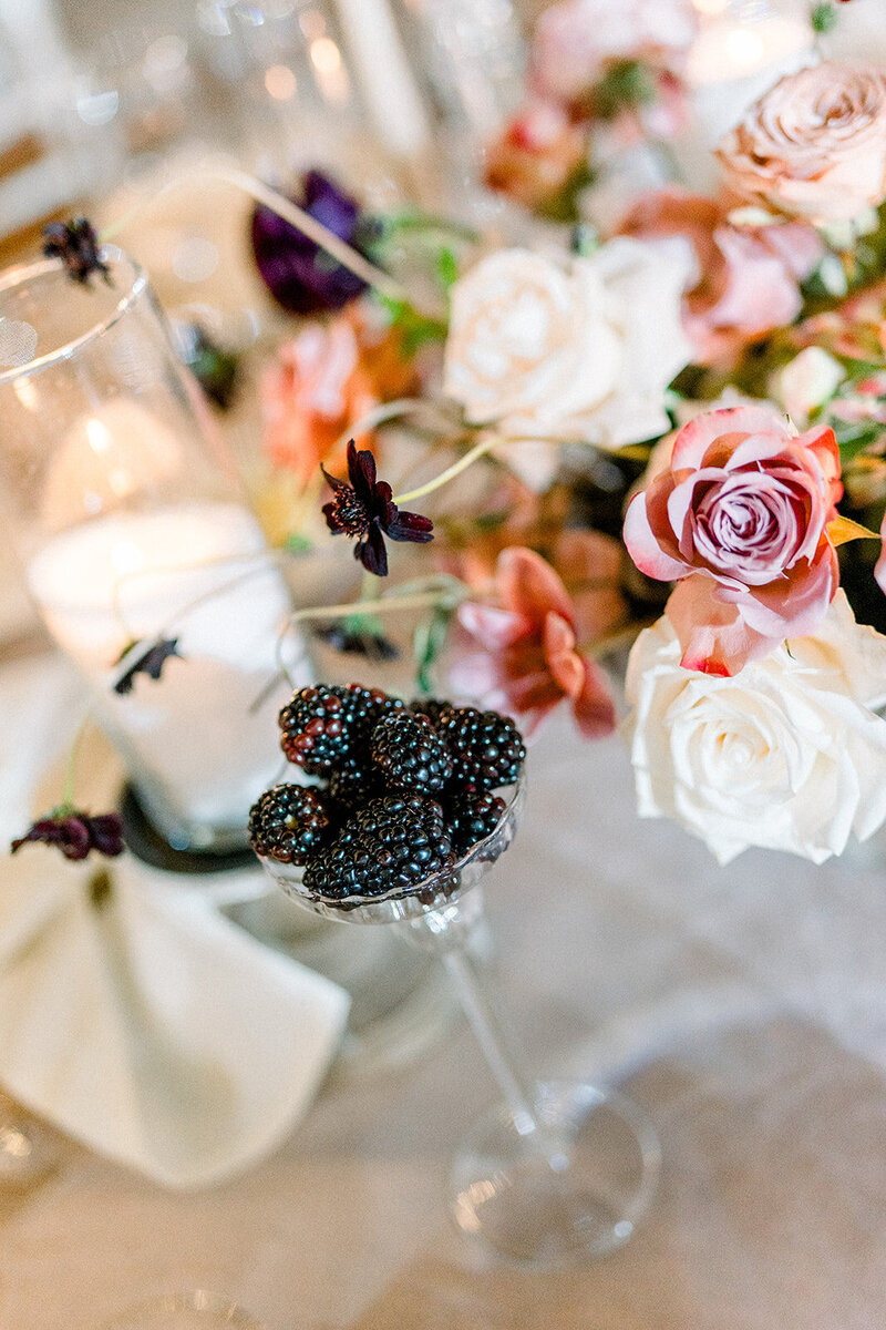 Romantic editorial-style tablescape with florals, blackberries, and candlelight at a wedding reception in Simi Valley at Hummingbird Nest Ranch
