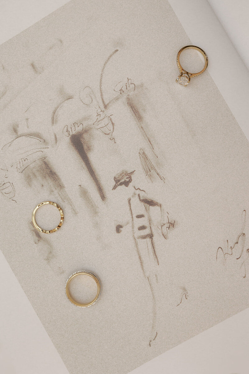 Wedding rings captured with art drawing as background