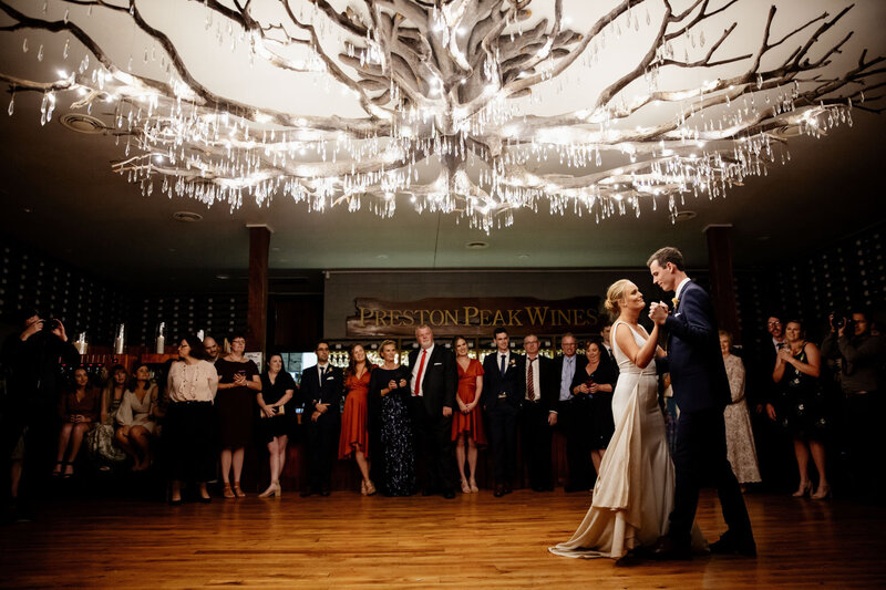 Bride and groom dance at wedding reception under the chandelier