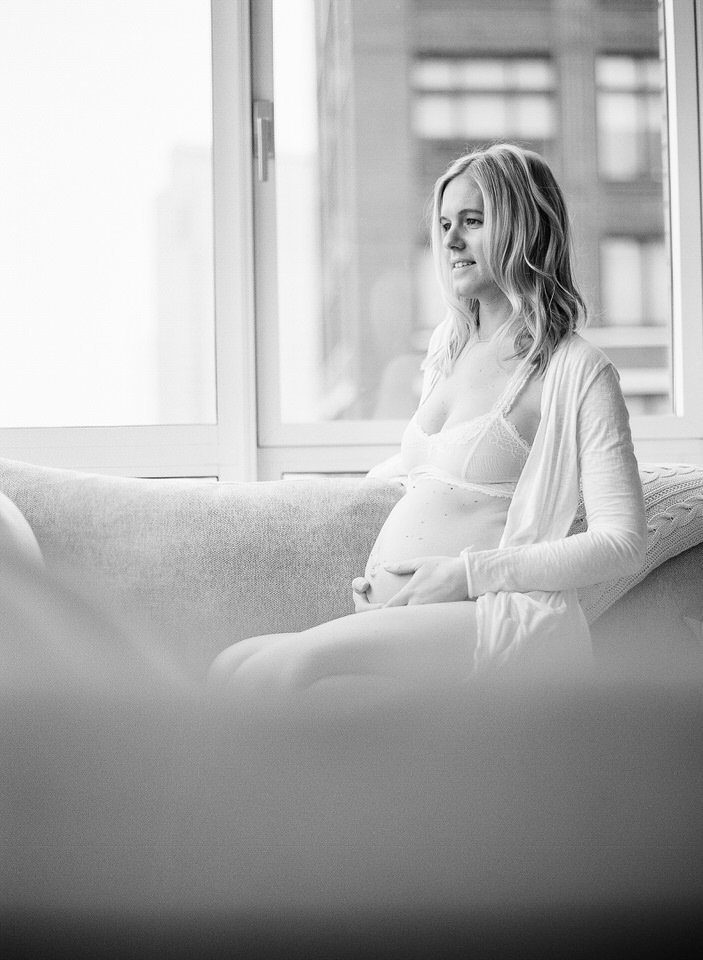 maternity pictures at home of a mom sitting on sofa