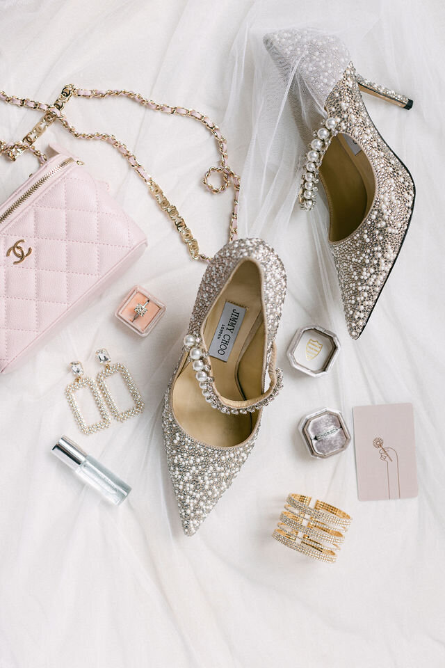Getting Ready Photos, Flat lays of neatly arranged wedding gown, matching shoes, and accompanying accessories elegantly displayed on a bed.