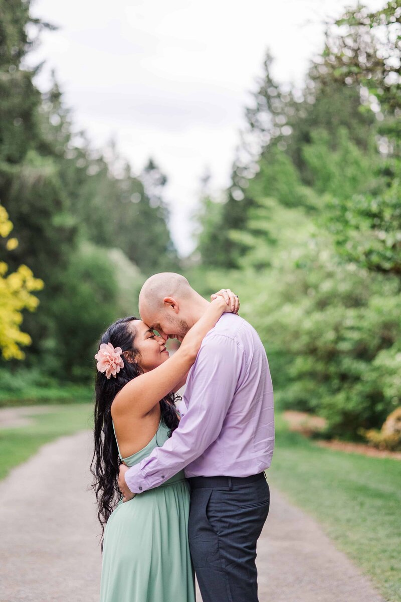 Couple with arms around each other at their engagement session at the University of Washington Arboretum