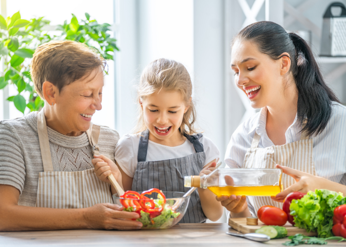 Thrive by Spectrum Pediatrics image for article titled introduction to the Spectrum Pediatrics tube weaning program is a child preparing food for mealtime with her mother and grandmother representing three generations