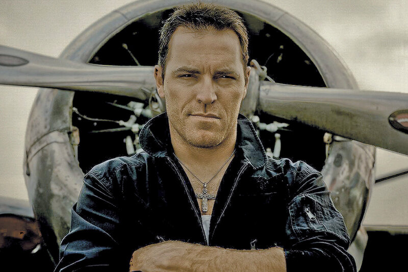 Country Music Portrait George Canyon standing in front of airplane propeller arms folded across chest