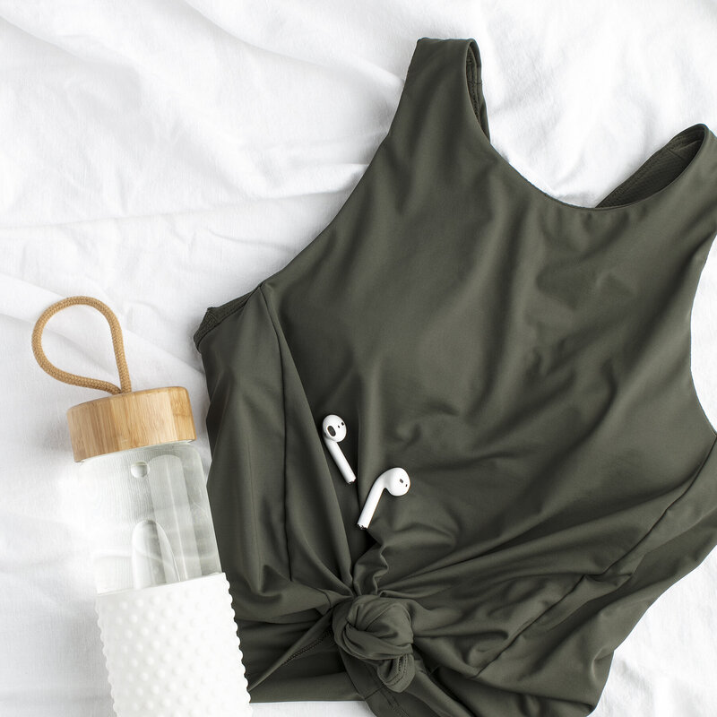 Green workout shirt with headphones and water bottle
