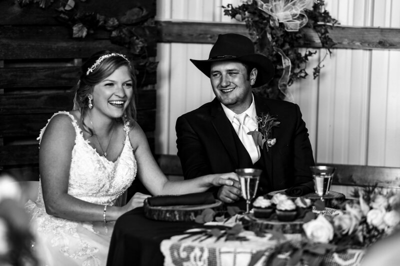 Bride and groom laughing together at head table during wedding reception in Waterford PA