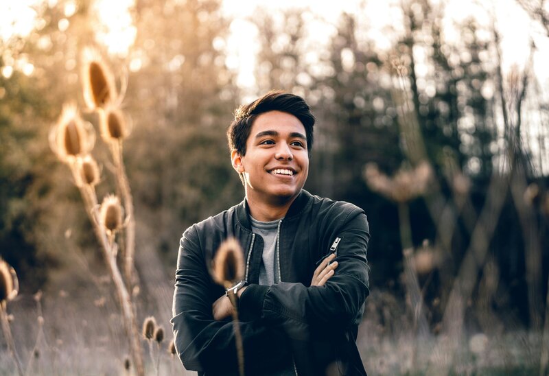 young man smiles in a field