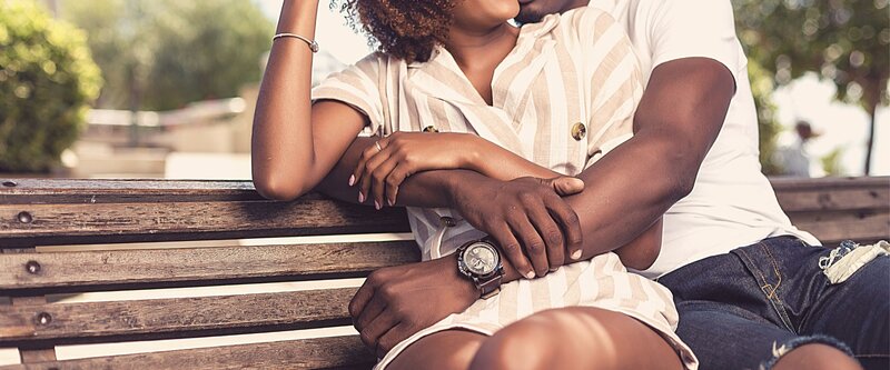 A couple sit and embrace one another on a bench. This could represent how a marriage counselor in Florida could benefit a relationship. contact a couples therapist in Florida for support today!