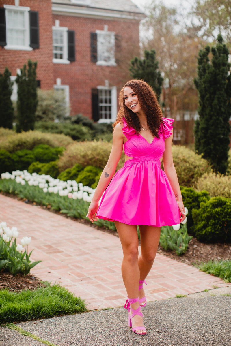 Highschool senior girl posing in front on fountain with short dress