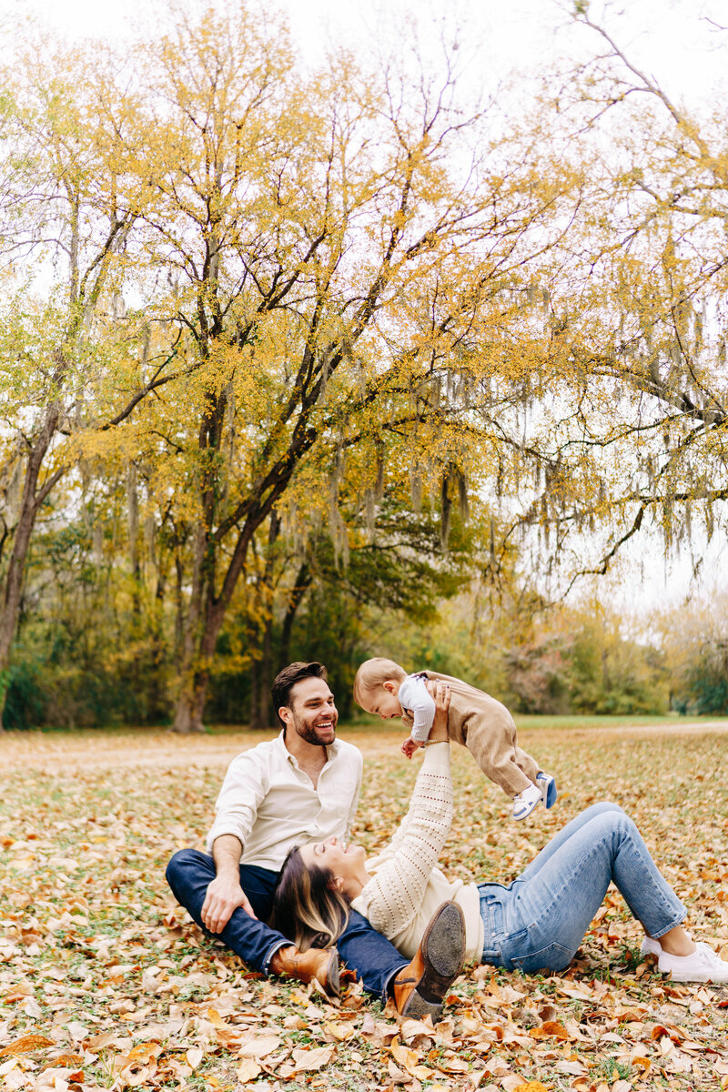 couple with their baby doing airplane in a family photo