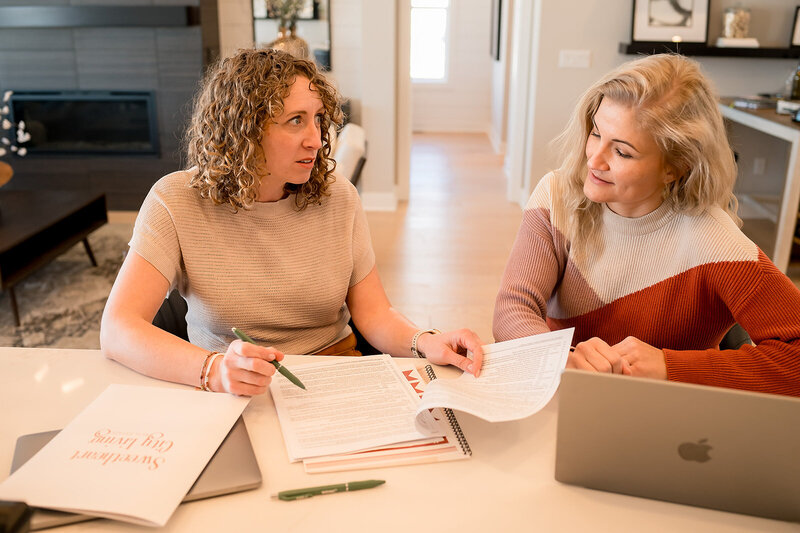 Two women smiling and talking during a home consultation