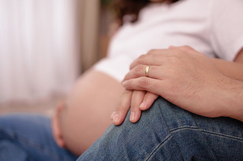 husband holding the hand of her pregnant wife
