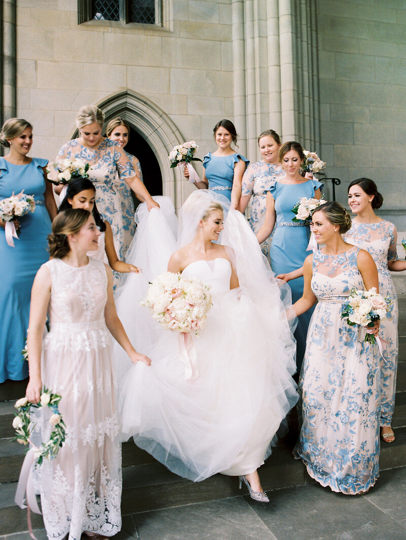 A bride and her bridal party giggle as they walk through the National Cathedral in Washington DC