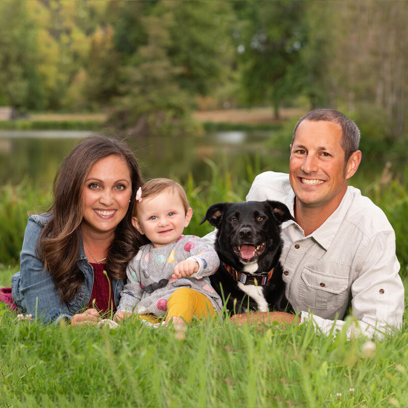 Picture of a couple with their baby and dog.