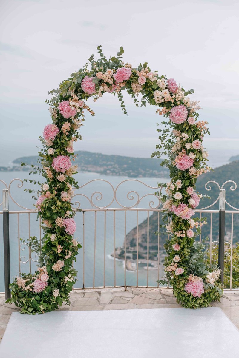 pink and green arch for a wedding ceremony in chateau de la chévre d'or in eze sur mer in south of france