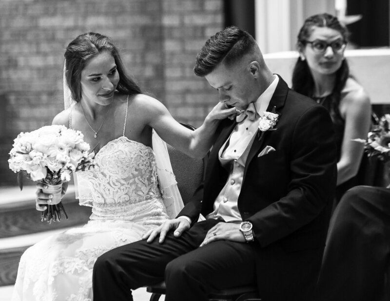 Bride fixes groom's  bowtie during wedding ceremony at Our Lady Peace church in Erie PA