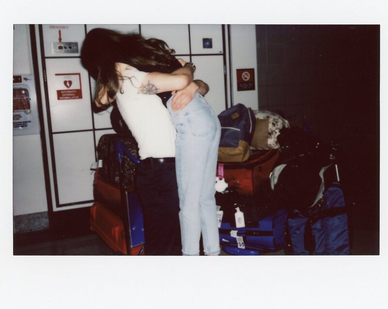 Polaroid of couple embracing in an airport