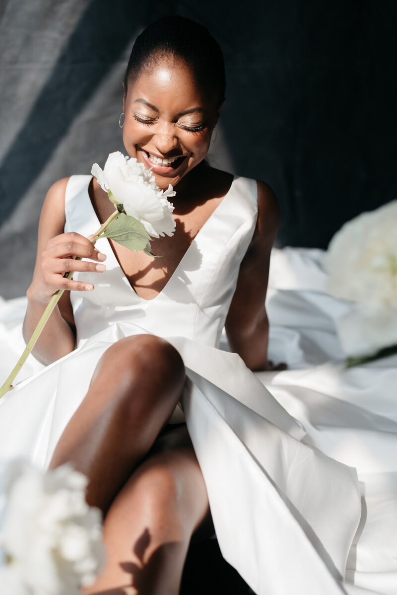 afro bride smelling rose smiling