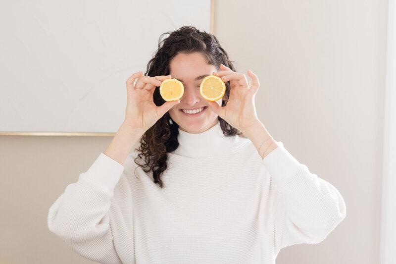 Grace playfully holding lemons up over her eyeballs