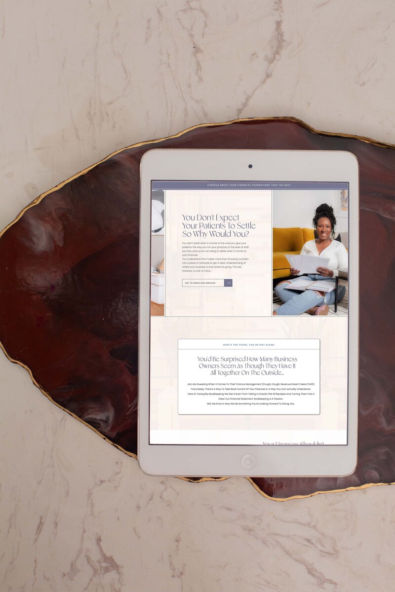 ipad on a purple stone displaying a showit website for an accountant