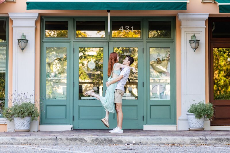 A cute young couple posing in front of downtown  Sarasota storefront