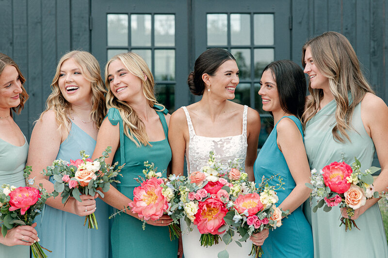 Bridesmaids and Bride laughing together at Morgan Creek Barn in Dripping Springs, Texas