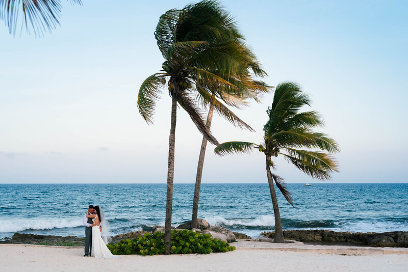 Luxury Wedding Portraits by Moving Mountains Photography in NC -  Photo of a bride and groom on the beach with palm trees.
