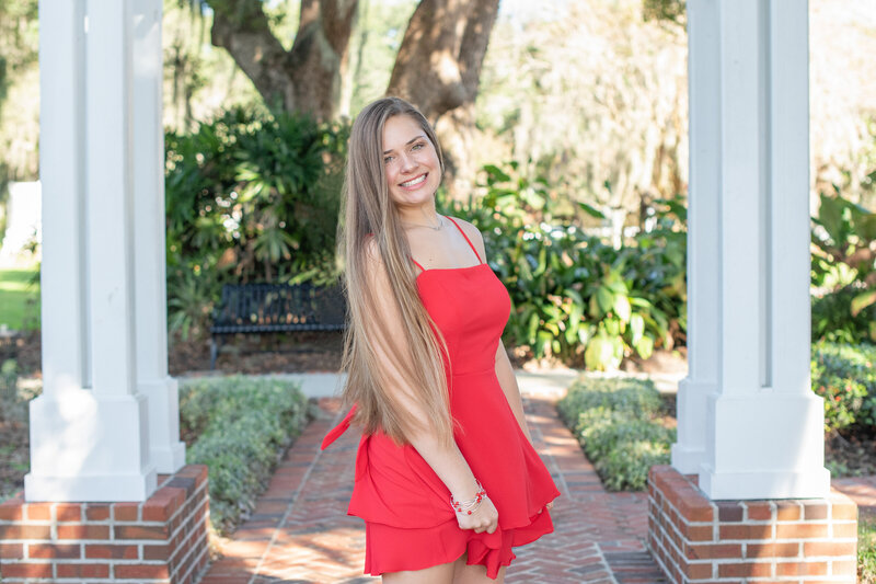 A golden hour photography session with a girl wearing a red dress in Orlando, Florida.