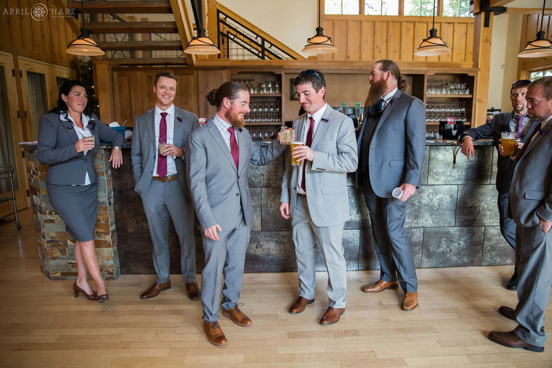 Groom hangs with friends with a drink at the bar inside the Silverthorne Pavilion