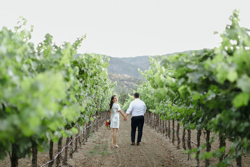 Couple walks through vineyards at Harvest Inn in St. Helena
