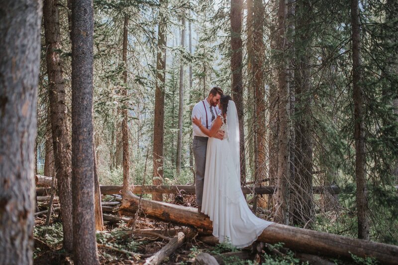 bride with veil and groom with suspenders share their first dance in a forest in a cozy elopement session in gatlinburg
