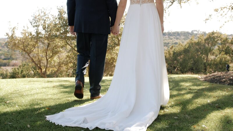 Bride and groom walk hand in hand on mountaintop venue