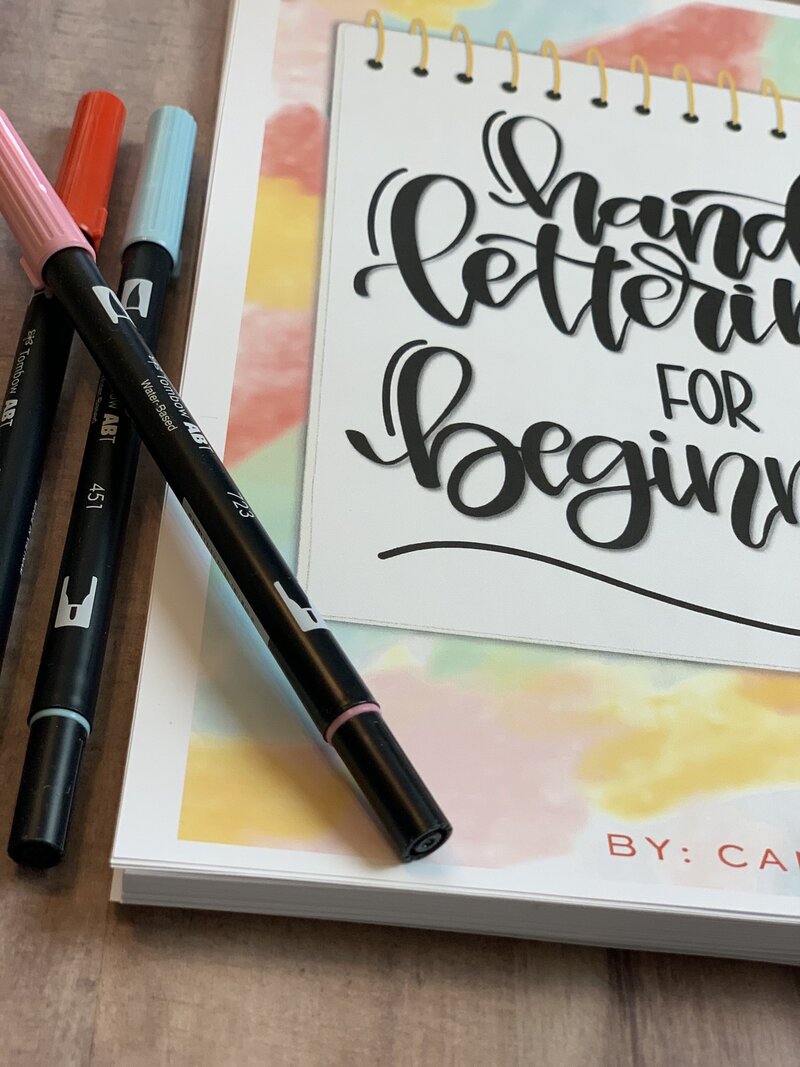 Multicolored book with black lettering pens