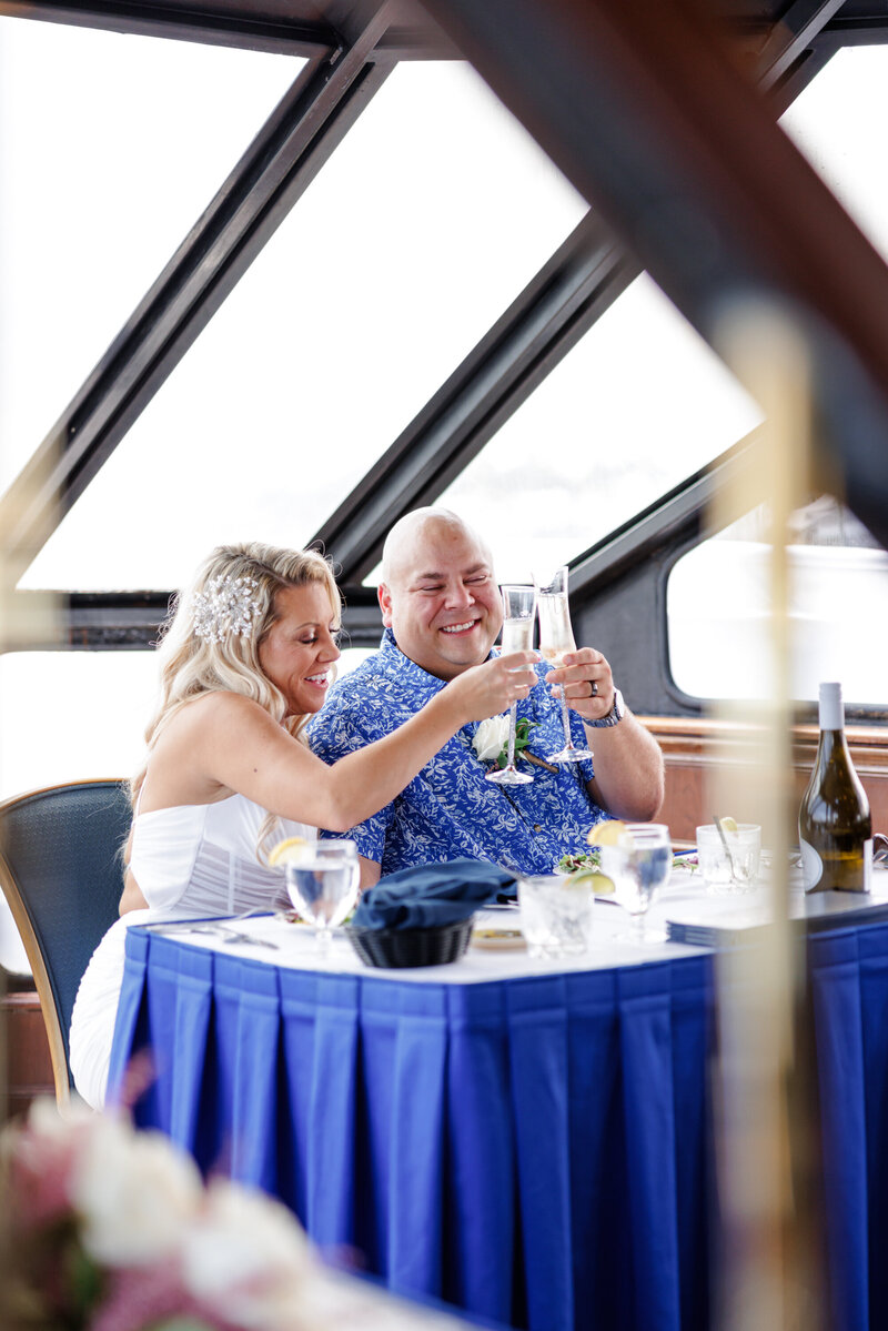 Bride and Groom raising glasses during a Florida yacht wedding celebration toasts. 
