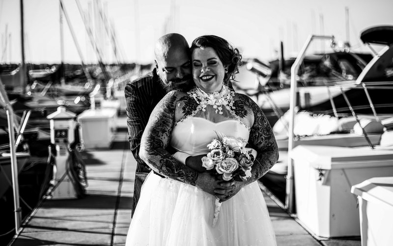 Groom embraces bride on the transient docks of the Erie Yacht Club