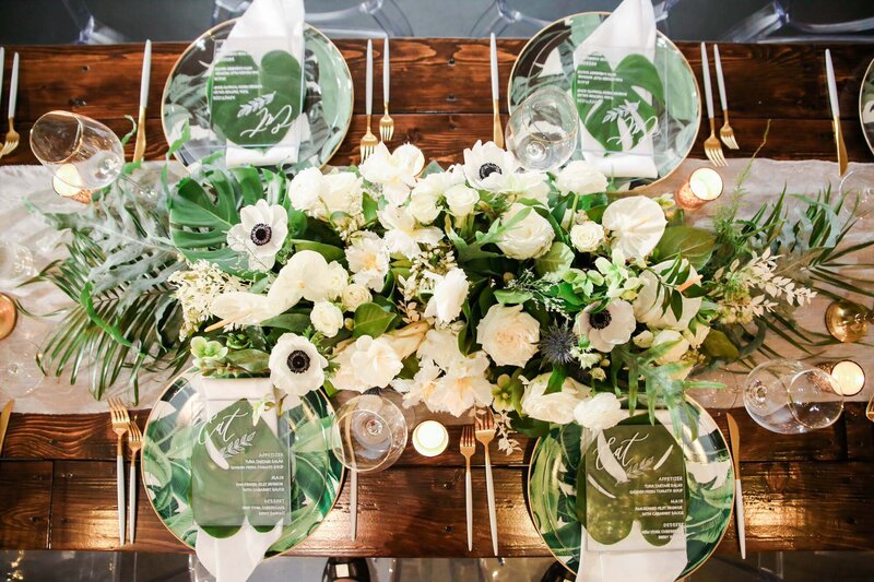 overhead shot of tropical wedding tablescape and floral centerpiece