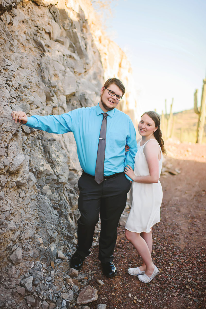 Husband and Wife leaning against rock with desert backdrop