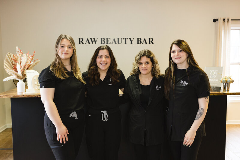 Raw Beauty Bar team members in front of beige wall