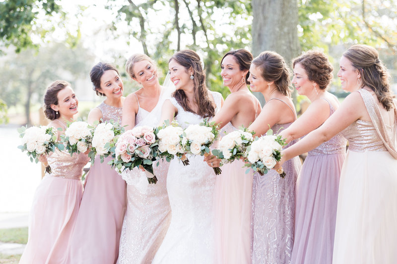 Bride and bridal party stand in a line holding bouquets
